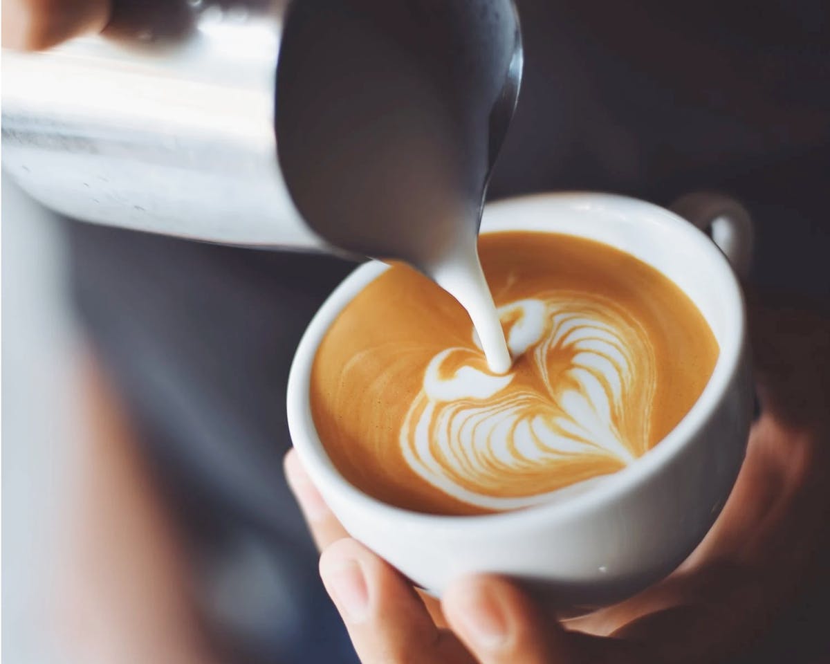 Pouring cream into coffee